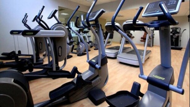 Ein Fitnessstudio mit verschiedenen Cardiogeräten, darunter Laufbänder und Crosstrainer.
