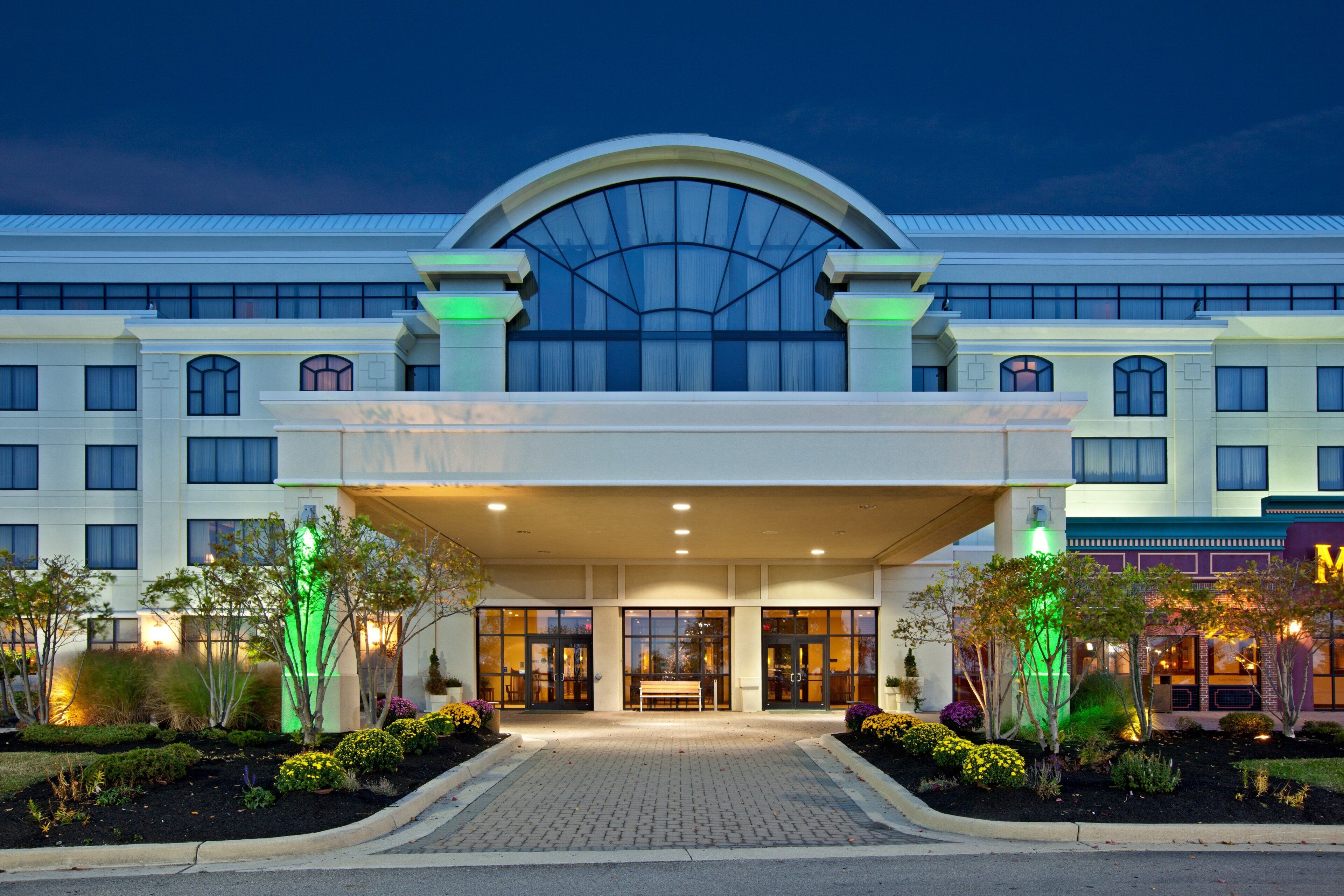 A hotel entrance with a covered walkway, large windows, and a prominent archway.