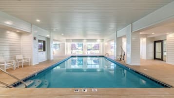 An indoor swimming pool with clear water, tiled floor, and a no diving sign.