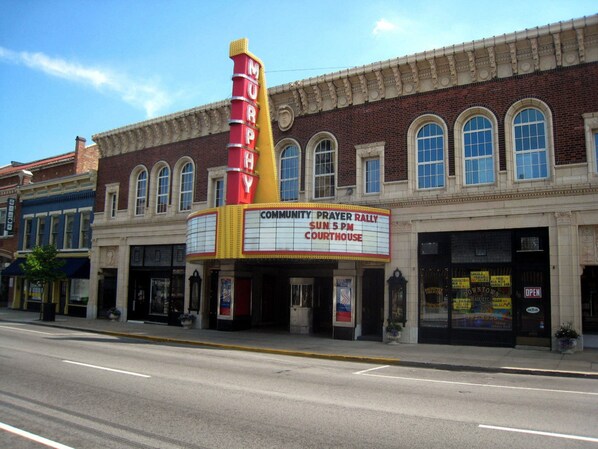 A theater with a marquee advertising a community prayer rally.