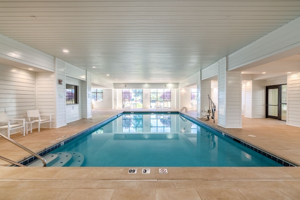 Una piscina interior con una profundidad de 2,8 metros, suelo de baldosas y paredes blancas.