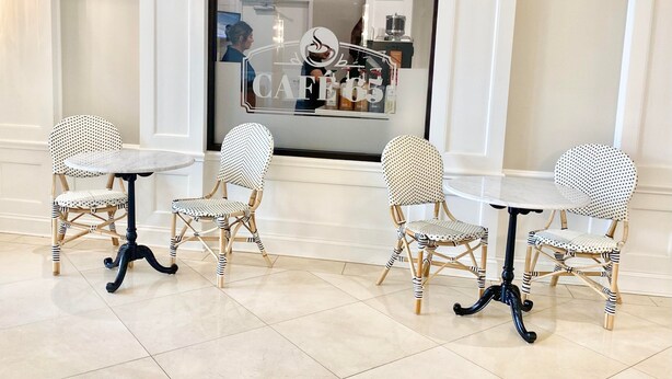 A seating area with four chairs and two tables, a Starbucks sign, and a fire alarm. - Holiday Inn Wilmington by IHG (Wilmington)