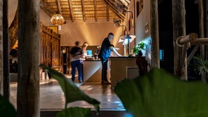 A restaurant with a rustic interior, including a wooden ceiling and a bar area.