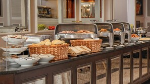 A buffet setup with various food items and serving ware.