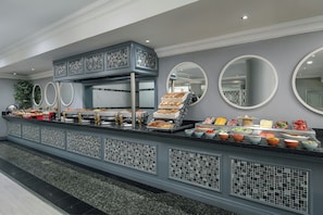 A buffet setup with various food items and a decorative mirror.