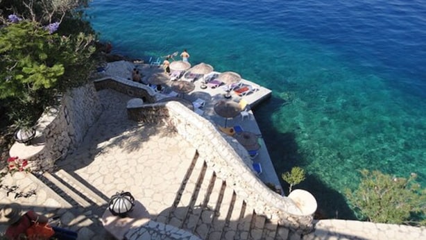 A stone staircase leading to a beach area with clear blue water, umbrellas, and lounge chairs. - Patara Prince Hotel & Resort (Kas)
