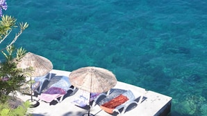 A poolside area with lounge chairs and umbrellas. - Patara Prince Hotel & Resort (Kas)