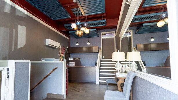 Ein modernes Interieur mit einer Rezeption, einer Sitzecke und einer Treppe.