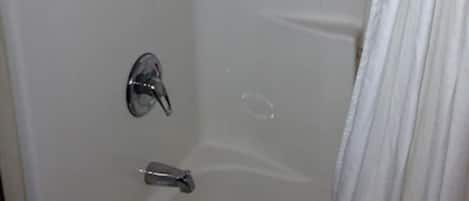 A small, enclosed shower area with a chrome faucet and a single control handle.