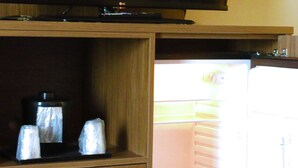 Ein Fernseher, der an einem Holzkasten über einer Küche mit Mikrowelle und Schublade befestigt ist.