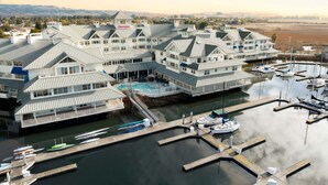 Un gran resort con varias construcciones, piscina y un puerto deportivo con barcos.
