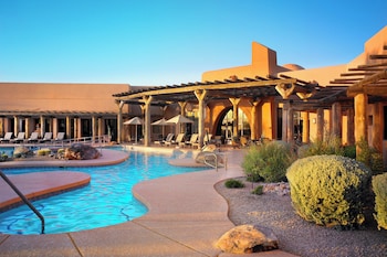An indoor dining area with tables and chairs, large windows, and a wooden ceiling. at Sheraton Grand at Wild Horse Pass