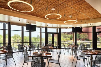 A long wooden table set for a formal outdoor event with white tableware, glassware, and floral centerpieces. at Sheraton Grand at Wild Horse Pass