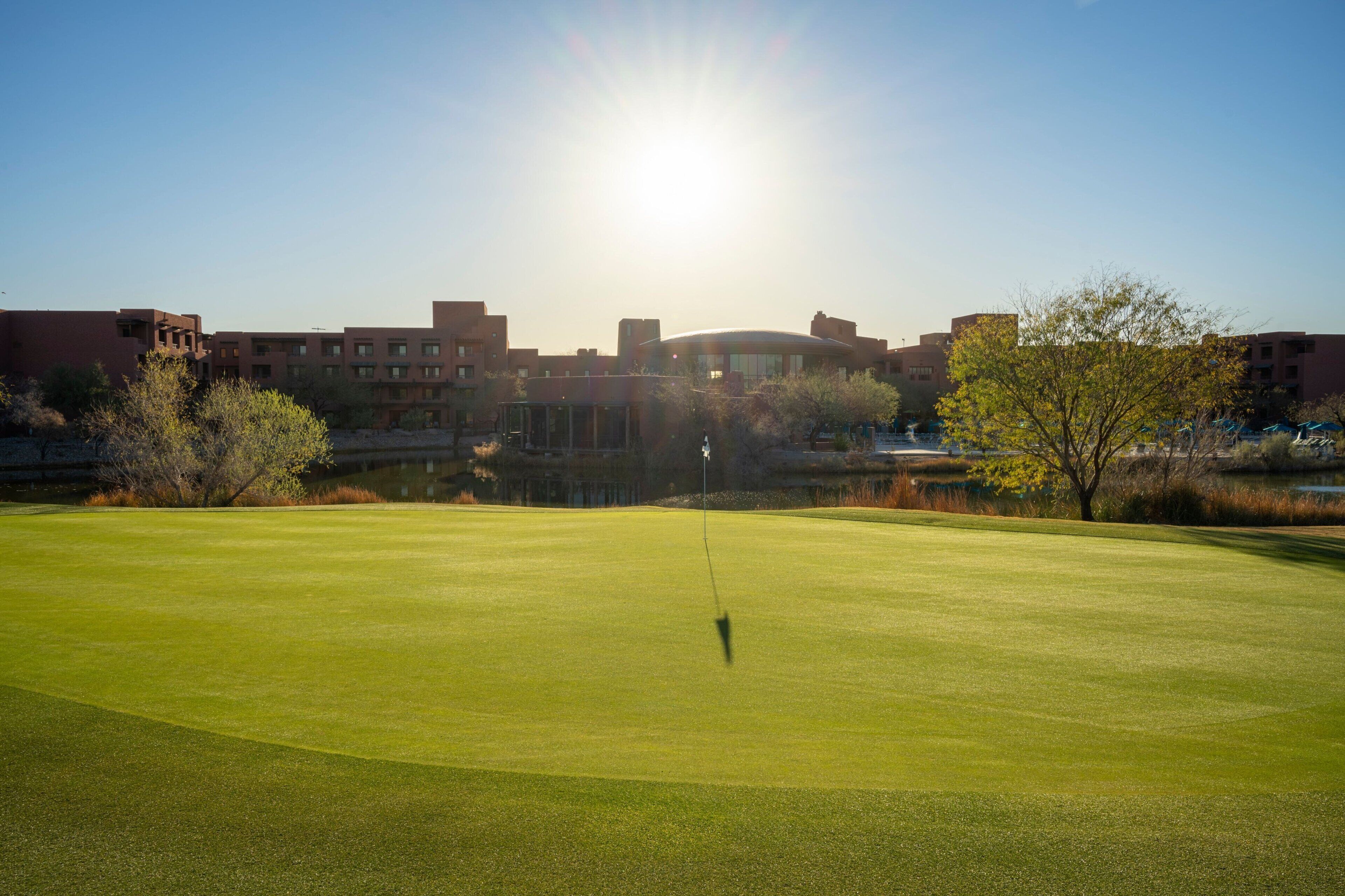 A golf course with a clear view of a building in the background.