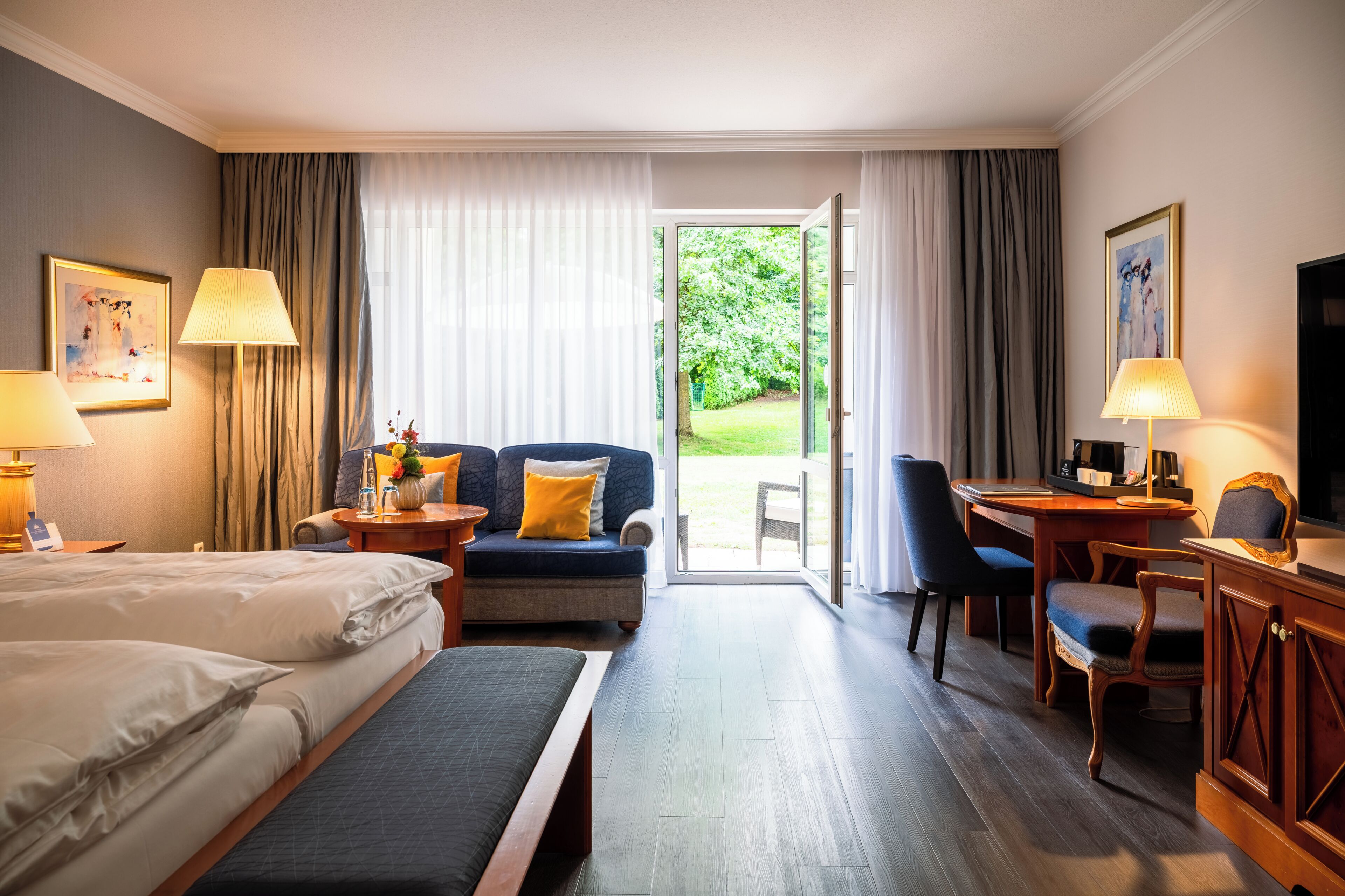 Une chambre d’hôtel avec deux lits, un canapé, un bureau et une télévision.