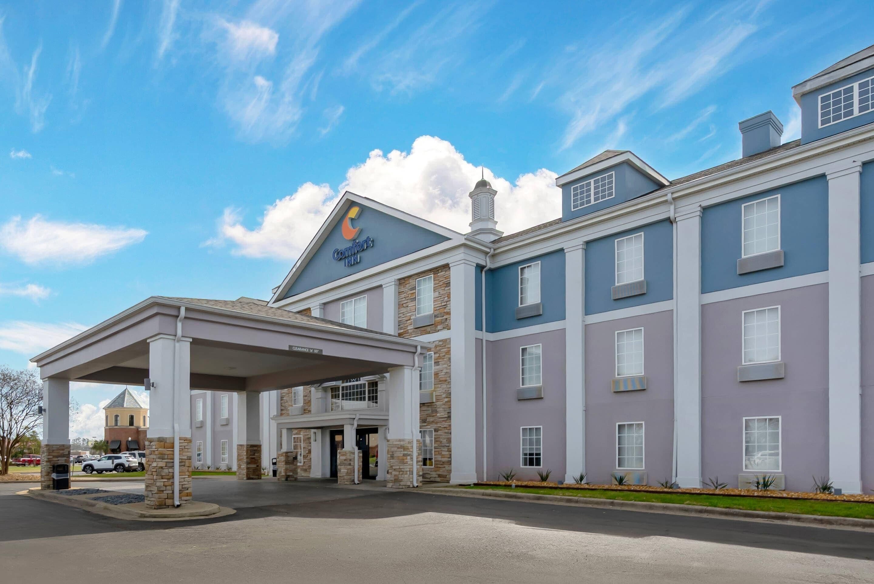 A hotel with a covered entrance, multiple floors, and a prominent 'Comforts Inn' sign.