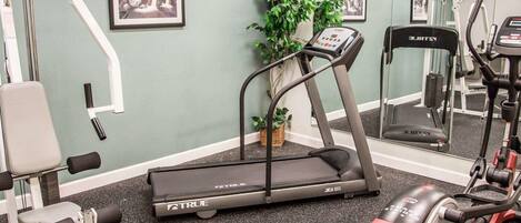 A gym with treadmills, exercise bikes, and weight machines.