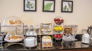 Un bufé de desayuno con diversas opciones de comida y una estación de café.