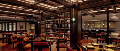 Een ruime restaurantruimte met houten tafels en stoelen, een hoog plafond met zichtbare balken en een traditioneel Aziatisch decor.