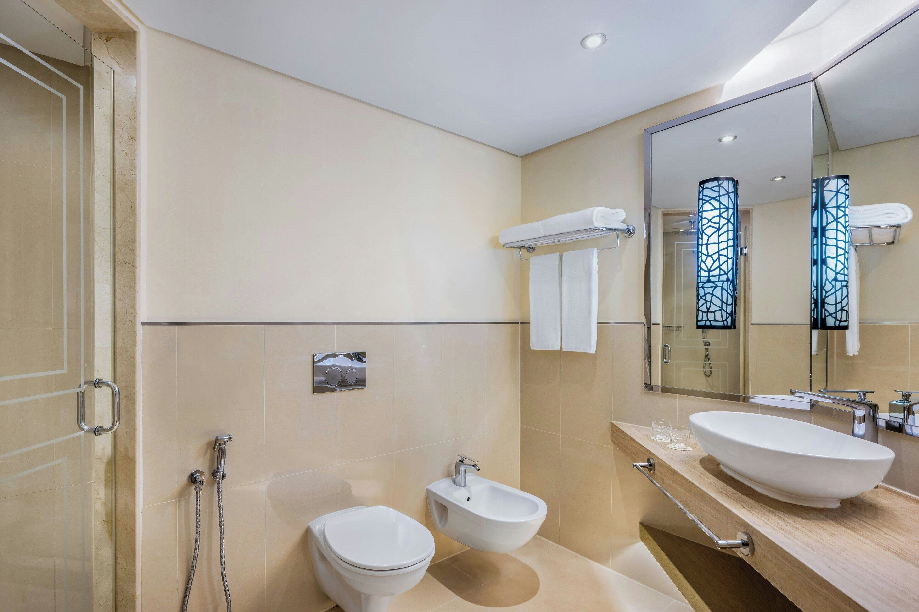 A modern bathroom with a toilet, bidet, and sink.