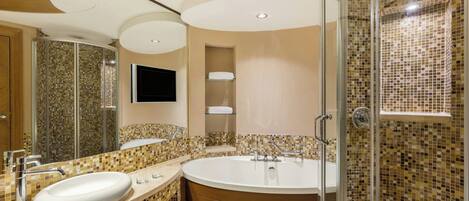 Un baño moderno con una bañera grande, una ducha con cerramiento de vidrio y un lavamanos con lavabo y espejo.