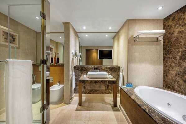 Un baño moderno con una bañera grande, un tocador con lavamanos y una zona de ducha.