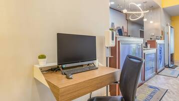 Un comptoir d’accueil avec un ordinateur, une chaise et une plante en pot.