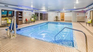 An indoor swimming pool with a tiled floor, a lifeguard chair, and a pool ladder. - The Leo Collection Detroit, an Ascend Collection Hotel (Lincoln Park)