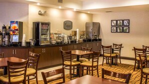 A hotel breakfast area with a counter, coffee machines, and seating. - Sleep Inn Raleigh Durham Airport (Durham)