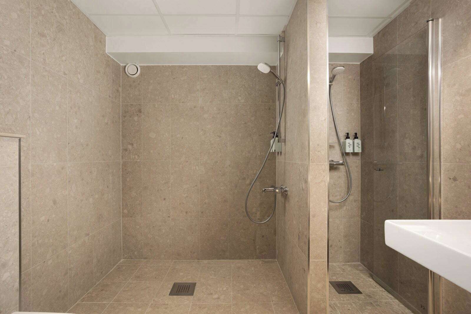 A modern bathroom with a walk-in shower, a toilet, and a sink.