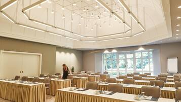 A conference room with tables, chairs, and a large window.