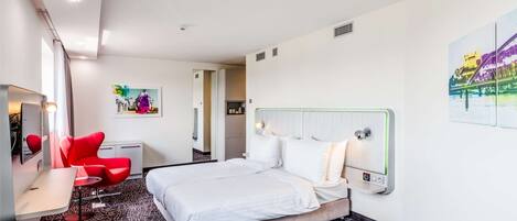 Une chambre d’hôtel avec un lit, un bureau, une chaise et un canapé.