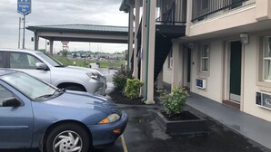 Un Knights Inn con área de estacionamiento techada, señal de salida visible y un edificio con balcón.