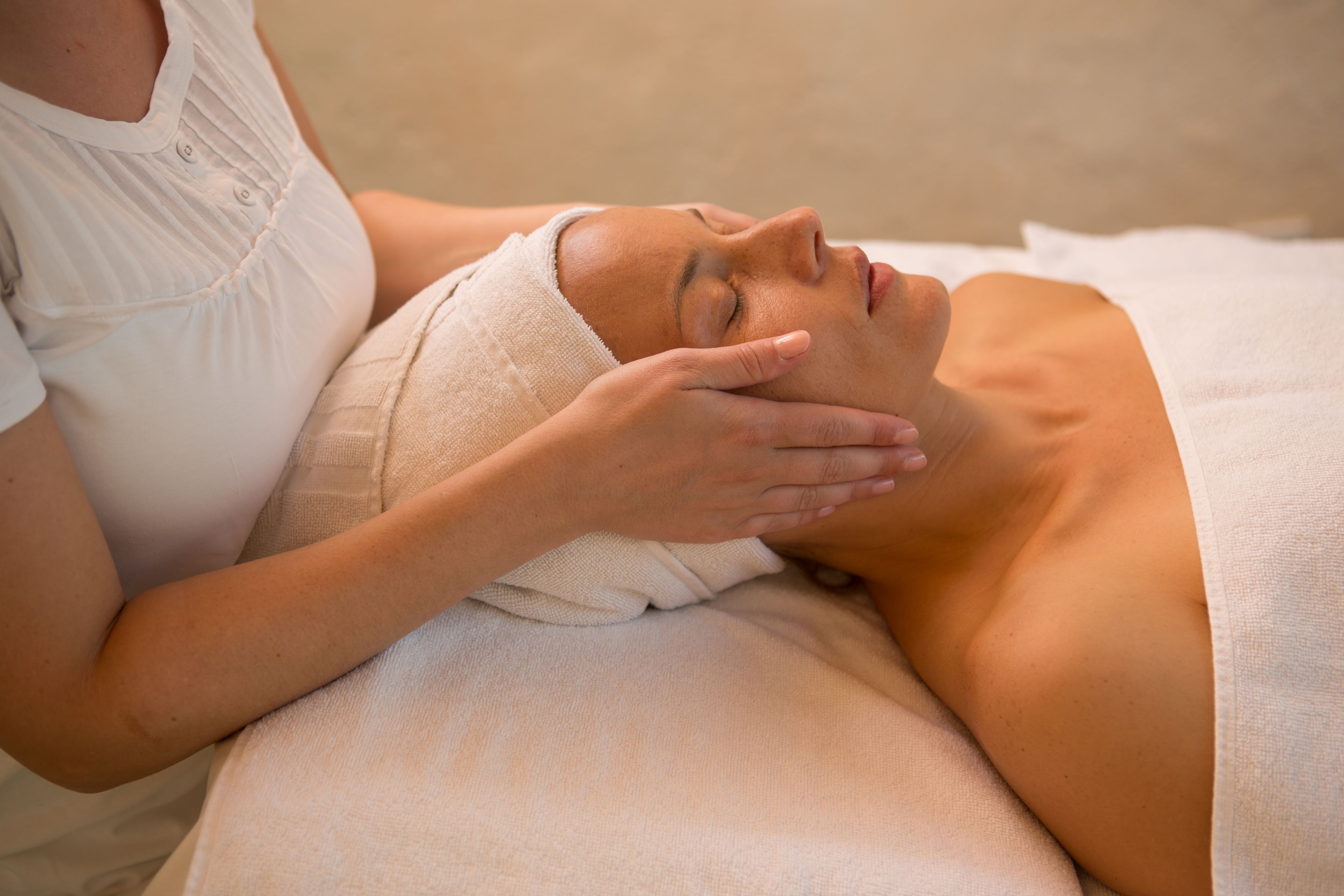 Une personne qui reçoit un massage, la tête enveloppée dans une serviette.