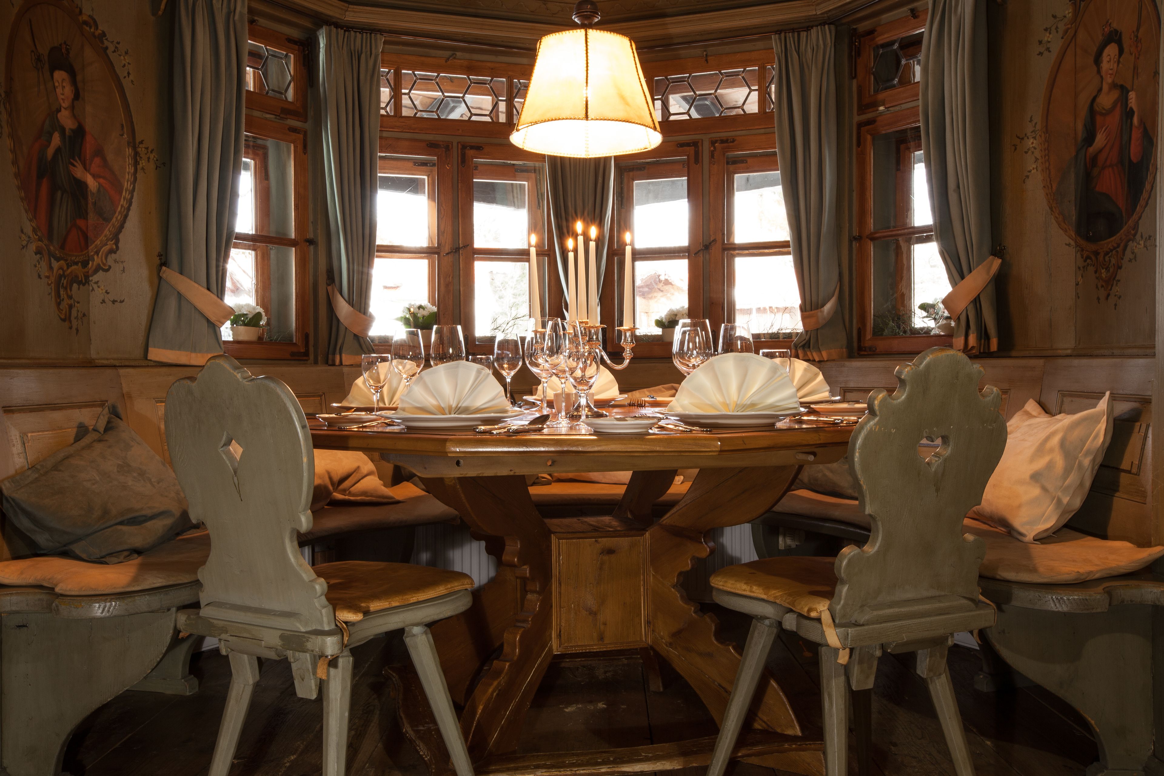A dining table set with plates, glasses, and a candelabra.