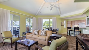 A spacious living area with a sofa, armchairs, a coffee table, and a dining area with chairs and a table. - Holua Resort (Kailua-Kona)
