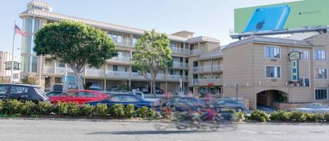 A multi-story hotel with a parking lot in front.