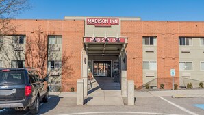 A brick building with a sign reading "Madison Inn by Ruby Hospitality."