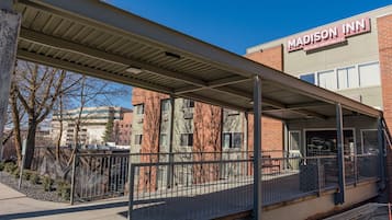 Un espace extérieur abrité, agrémenté d’une enseigne indiquant « Madison Inn, établissement du groupe Ruby Hospitality ».