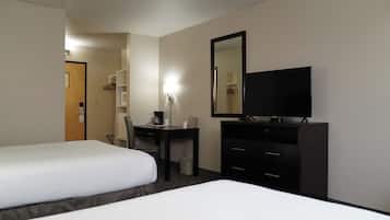 Une chambre d’hôtel avec deux lits, un bureau avec une chaise, une télévision et une armoire.