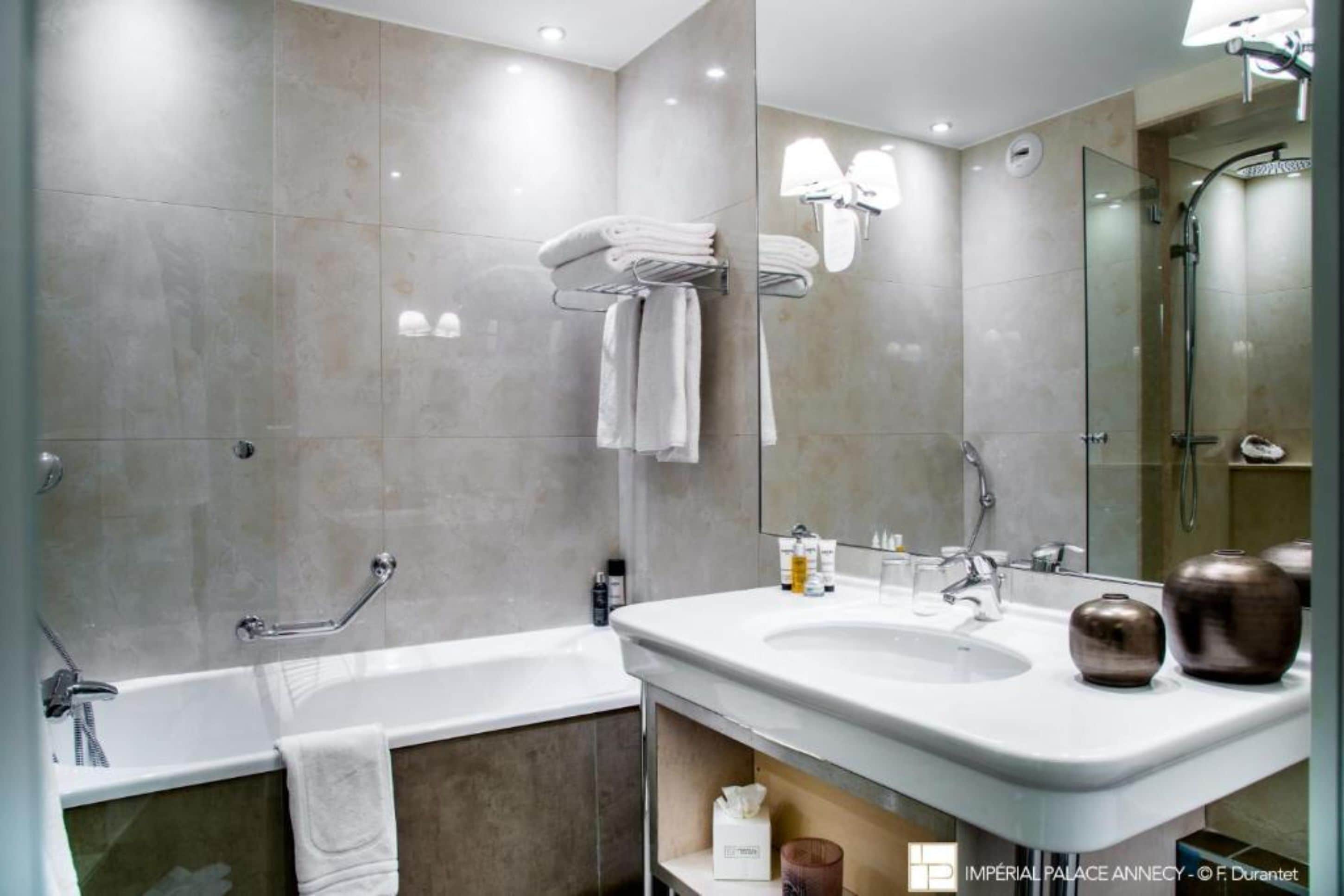 A modern bathroom with a bathtub, a vanity with a sink, and a glass shower enclosure.