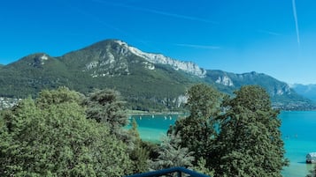 A mountainous landscape with a clear blue sky, a lake, and a view of a town in the distance.