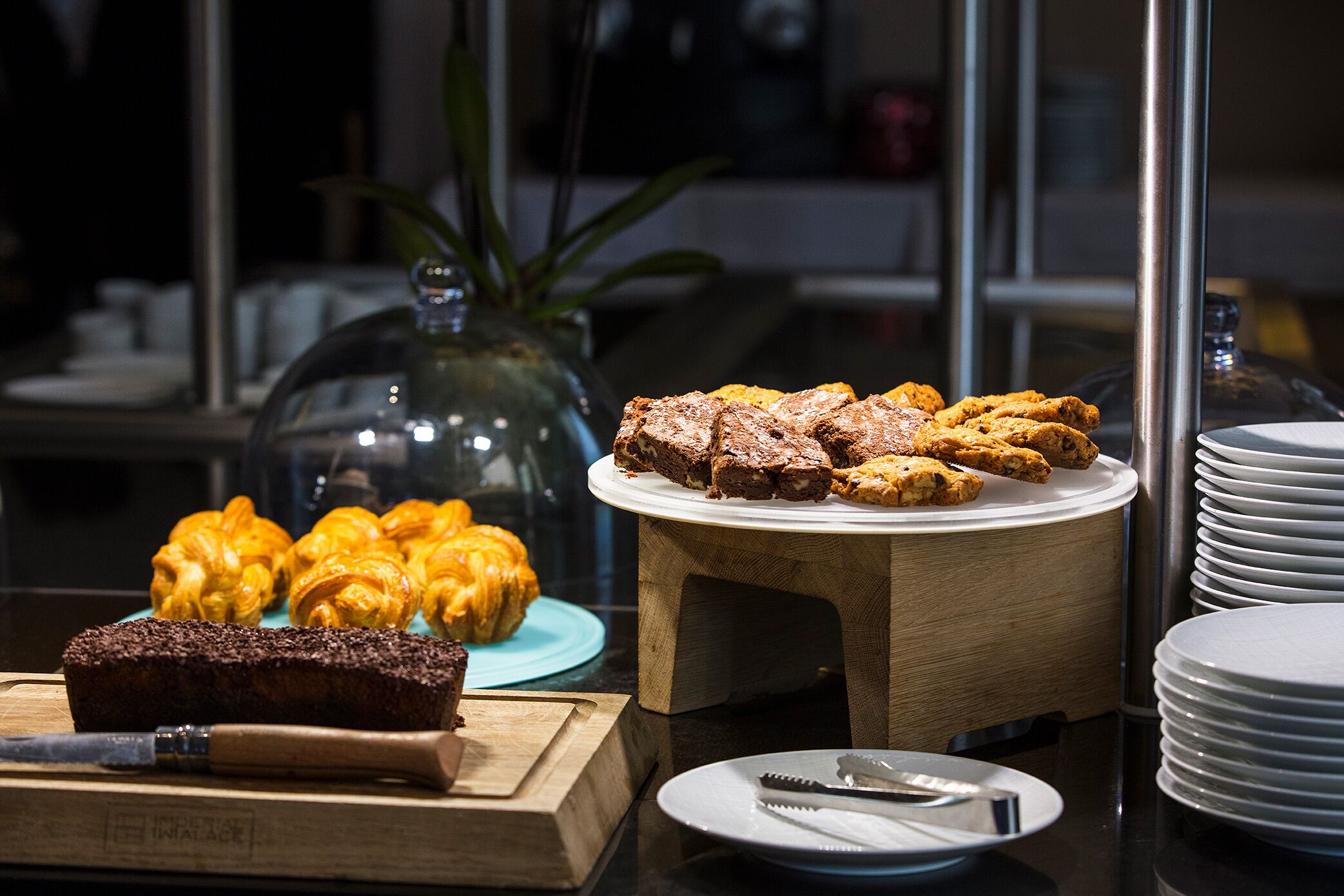 Una mesa de buffet con diversos productos de panadería, incluyendo hogaza de pan y pasteles.