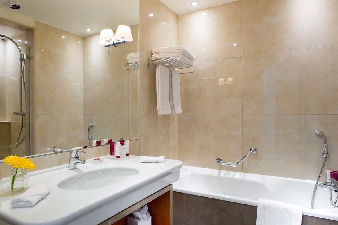 A modern bathroom with a double sink, a bathtub, and a shower.