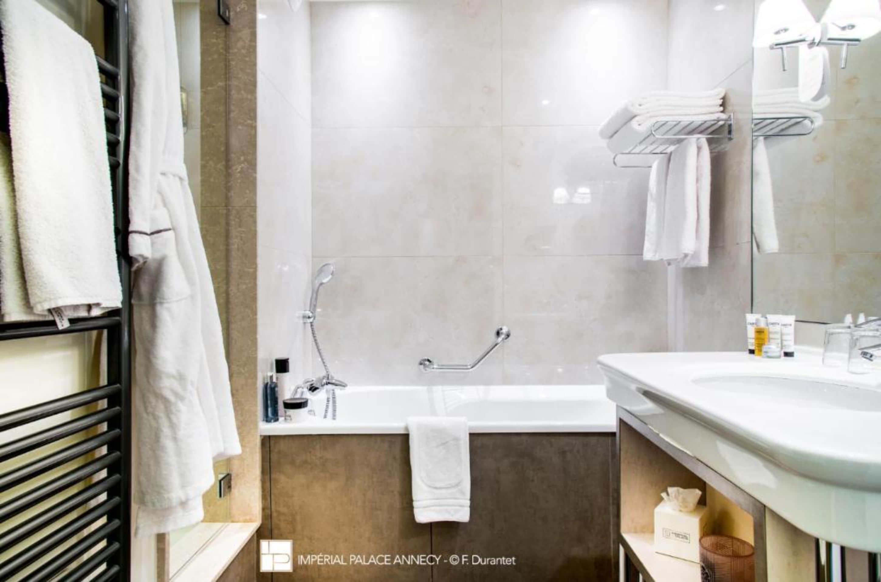 Un baño moderno con una bañera, un lavabo y un perchero para toallas.