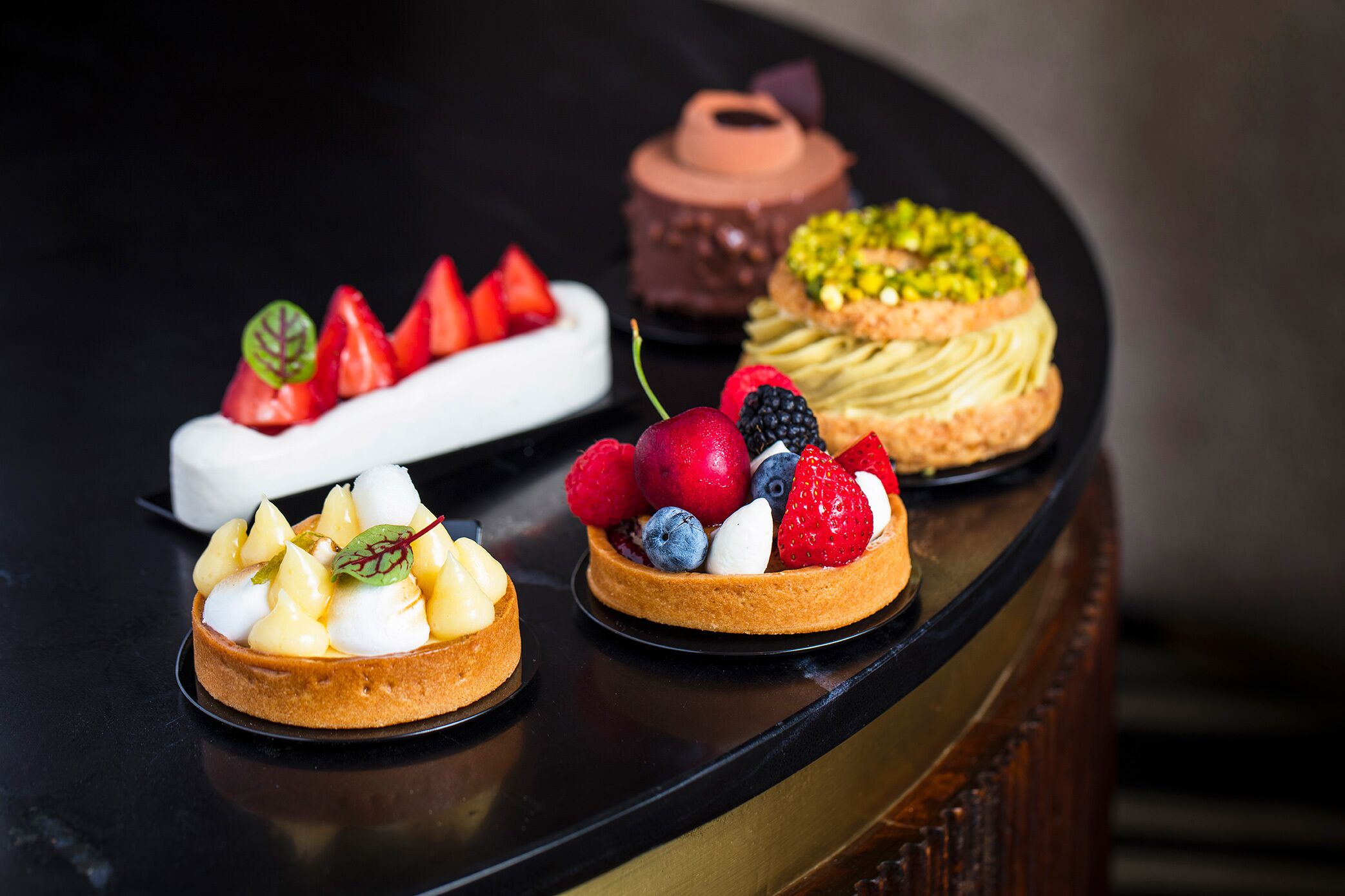 Tres postres sobre una mesa negra.