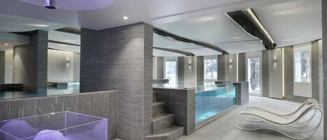 Un espace spa moderne doté d’un jacuzzi à ciel ouvert, d’un comptoir d’accueil et d’un fauteuil de relaxation.