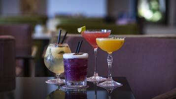 A table with four different cocktails in martini glasses.