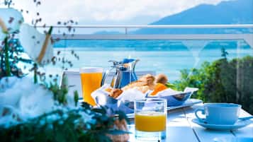 Una mesa de desayuno con vistas al mar y a las montañas.