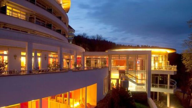 Un hotel de varios pisos con un diseño moderno, con balcones y ventanas amplias.